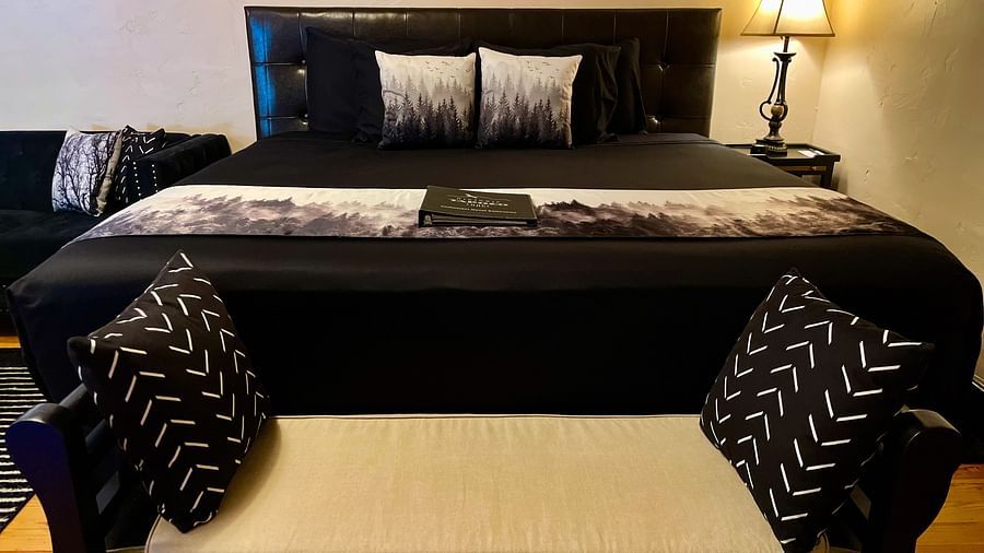 front view image of the double bed along with a small seating place in front of it - Historic Tapoco Lodge