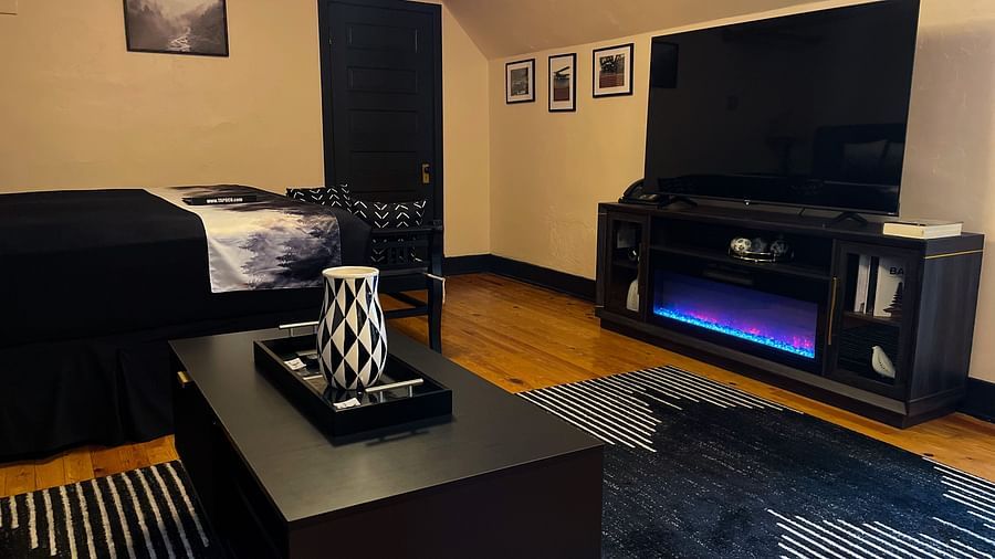 a common seating area featuring a wide flat screen television complimented by a sound system - Historic Tapoco Lodge