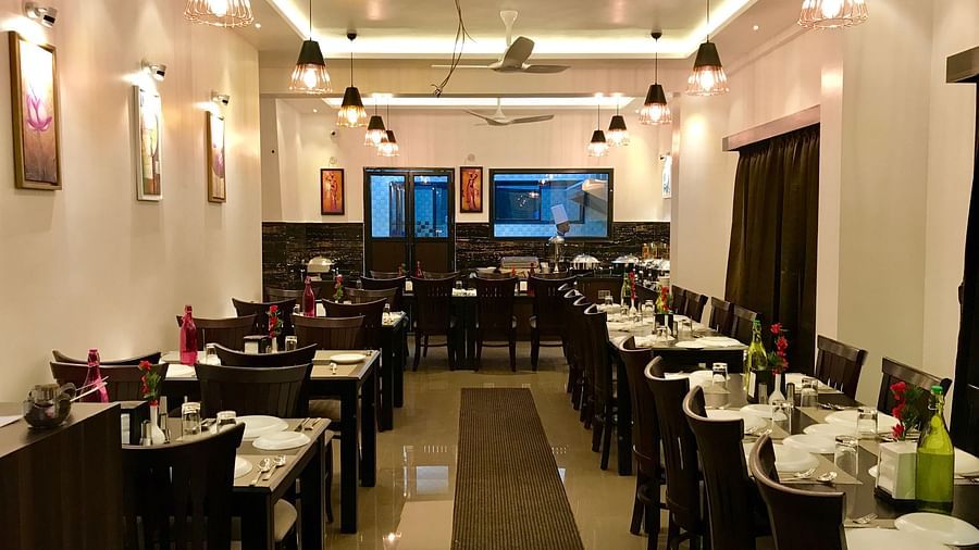 Image of a dining area with crockeries placed on the table at Hotel Altitude, Madikeri.