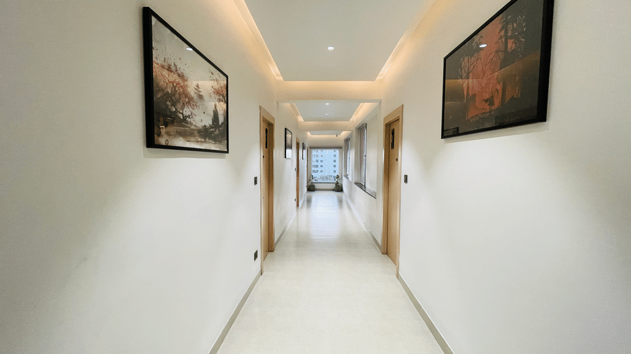 IMG 5922A clean well-lit hotel corridor at Hotel Kyzen HiTech City featuring white walls warm recessed lighting dark flooring framed artwork and a long passageway leading to the rooms..JPG