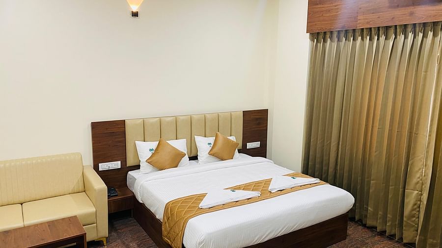 Neatly arranged room with golden accents, plush bedding, and warm lighting at Hotel Sahara Tree.