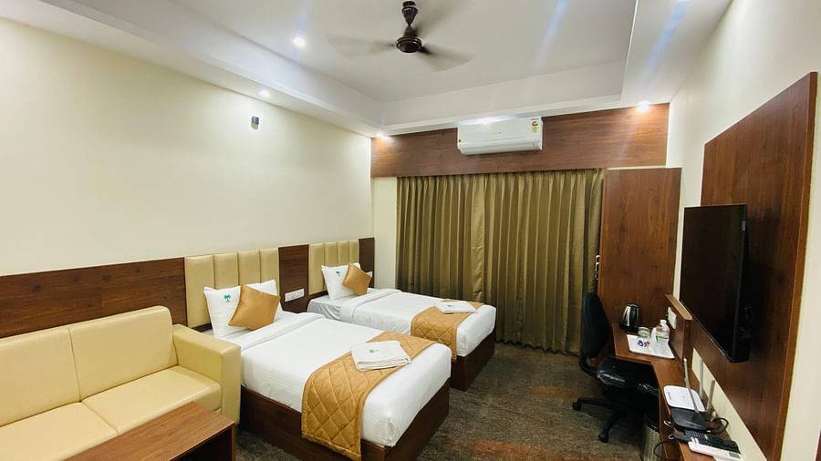 Elegant room featuring large bed, full-length curtains, and cosy ambience at Hotel Sahara Tree.