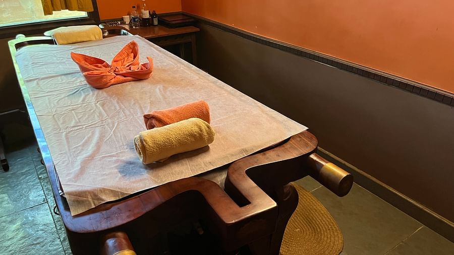 image of the bed at the Ayurveda spa with decorated towels on it at hoysala village resort in hassan