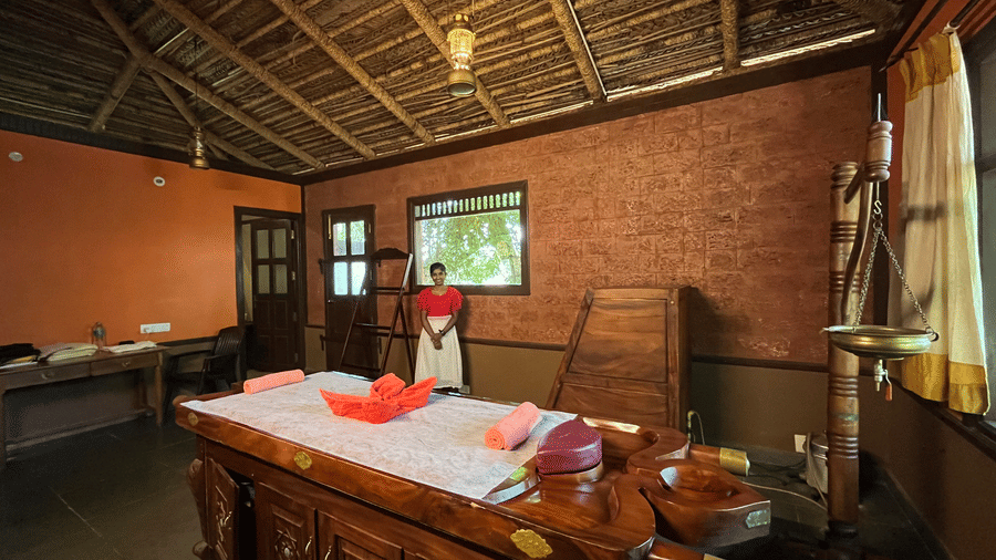 A serene spa room with warm wooden interiors, a massage table and soft lighting, creating a calm and inviting space for relaxation at Hoysala Village Resort, Hassan.