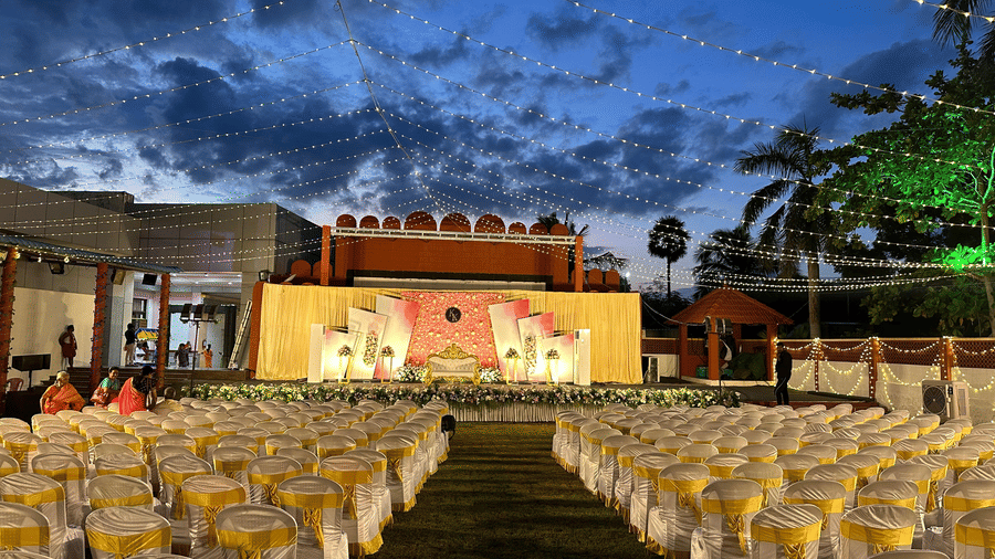 An extensive outdoor seating arrangement with white and gold chairs set up for a large-scale event or wedding reception - Kailash Conventions ECR