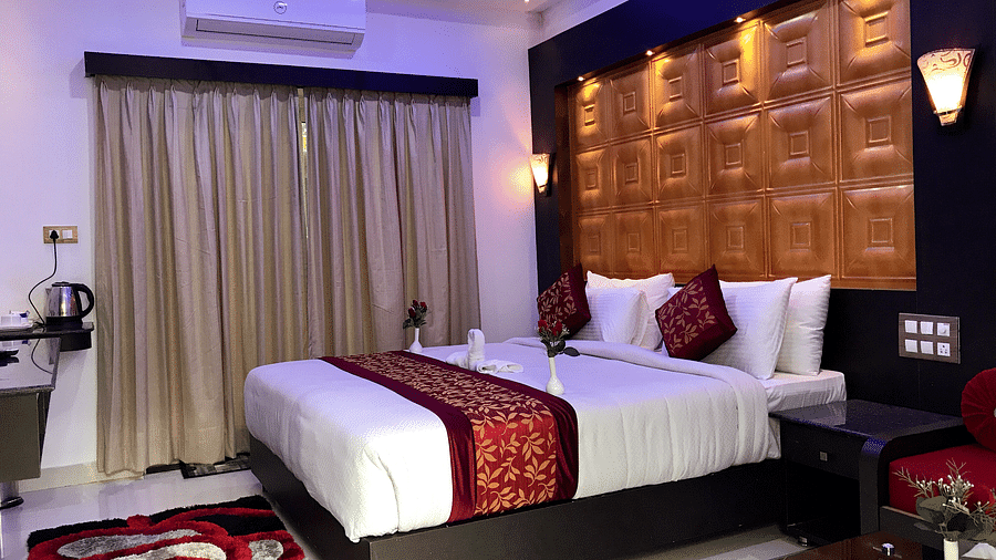 A room with a bed and a window on the side at Parampara Resort & Spa, Kushalnagar.