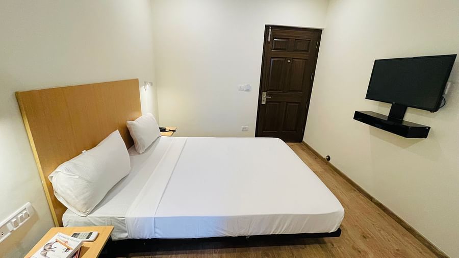 A double bed and a TV in a room at Sanctum Suites Richmond Road Bangalore