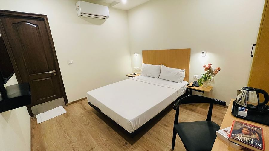 A double bed and a work desk at Sanctum Suites Richmond Road Bangalore