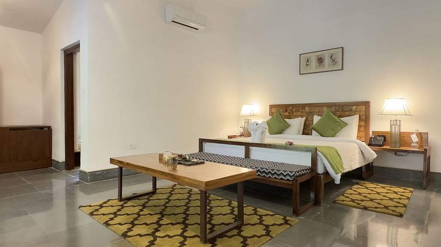Sanctuary Suite at Saraca Resort & Spa Corbett with a double bed and a coffee table placed in front of the bed on a carpet