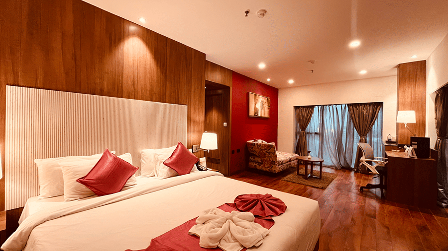 A wide angle shot of the bedroom of the Superior Smart Suite featuring a plush king size bed along witht he separate living area at the far end at Senses Hotel.