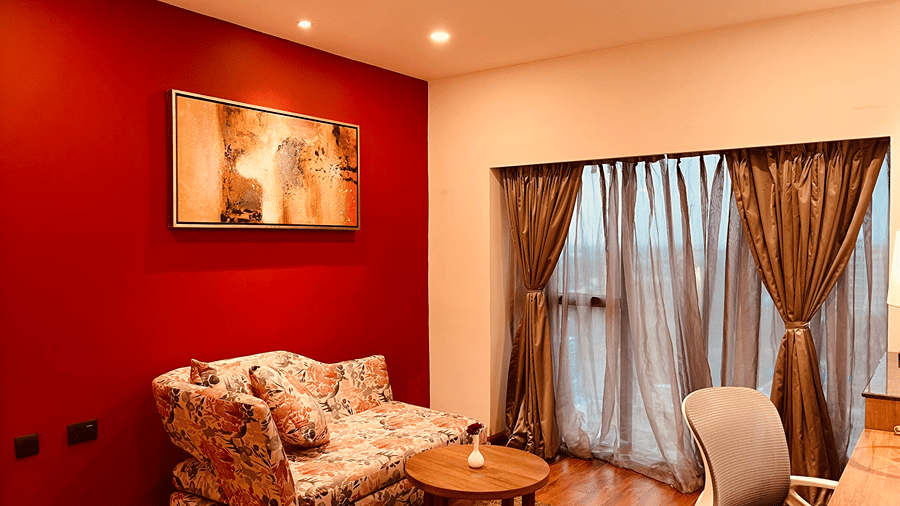 Corner view of the separate living area with a floral patterned couch and a small coffee table in front of it at Senses Hotel.