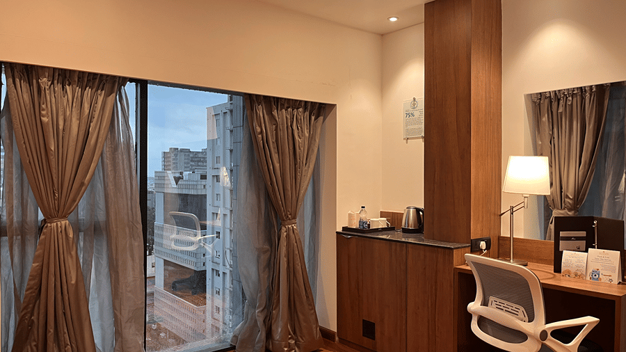 Corner view of living area of the Superior Smart Suite featuring a work desk and chair and huge french windows overlooking the city views at Senses Hotel.