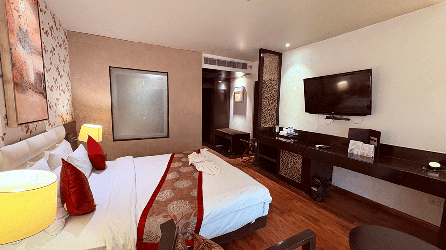 Corner view shot of the Executive Room highlighting a double bed along with a wall mounted television opposite to it - Senses Hotel