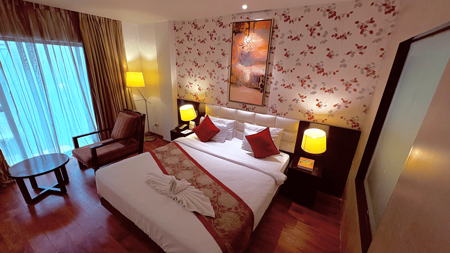 Top angle shot featuring the double bed in the Executive Room with two bed side lamps besides it - Senses Hotel