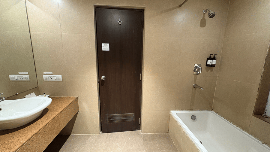 The bathroom of the Executive Room featuring the entrance door along with a full size bath tub in the corner - Senses Hotel
