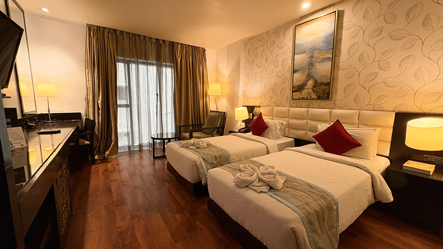 The Executive Room with ample of natural lighting featuring a twin bed setup with wooden flooring in the room - Senses Hotel