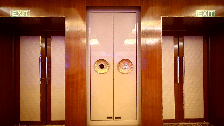 A tall door white in colour with two huge door knobs - Senses Hotel