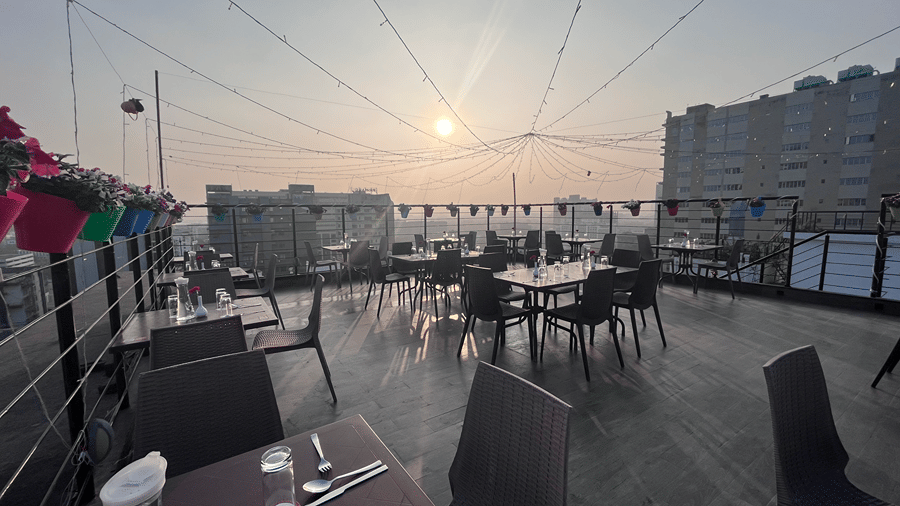 Rooftop dining setup with a scenic view and morning sun - Senses Hotel