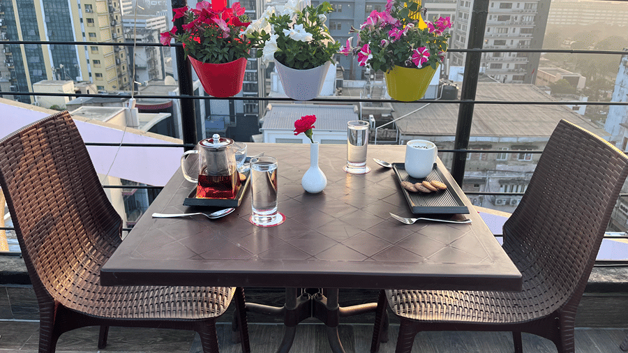 Table and chairs with beverages and snacks set up for rooftop dining.