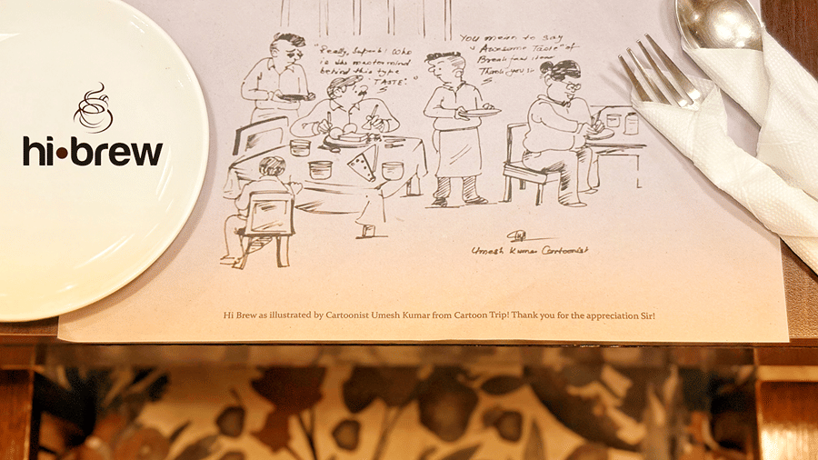 A table mat made of paper with a fork and spoon placed over it wrapped in tissues.