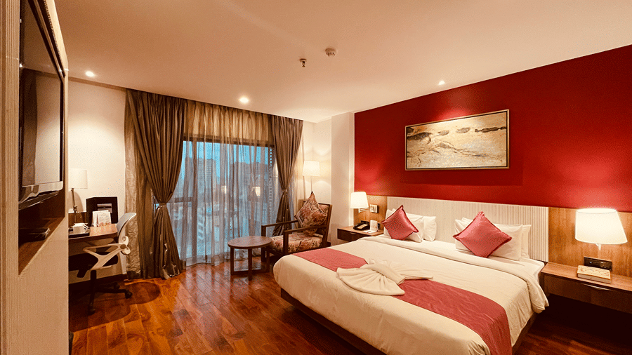 Full view shot of the Superior Room featuring a double bed with wooden flooring and a red coloured master wall - Senses Hotel