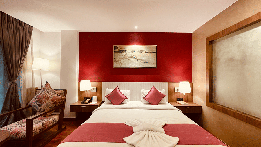 Front view image of the Superior Room with a double bed and a cushioned armchair in the corner - Senses Hotel