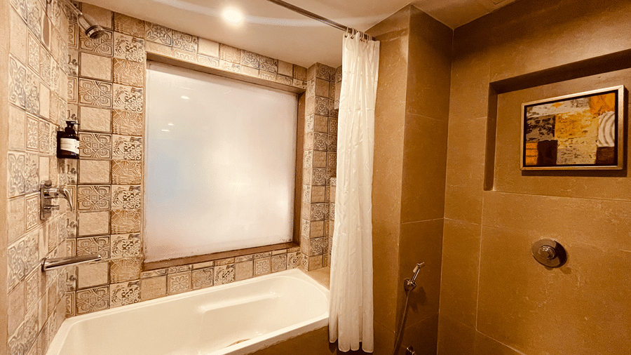 A bathroom featuring a bathtub with a huge translucent glass window above it in the Superior Room - Senses Hotel