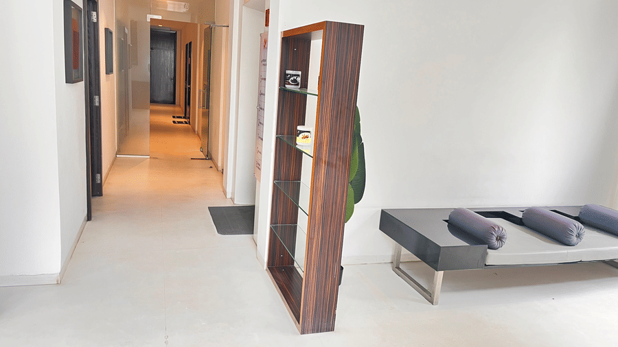 A bright hallway with a wooden divider, cushioned seating, and neatly arranged towels creating a welcoming, calming environment at Springs Hotel & Spa, Bangalore