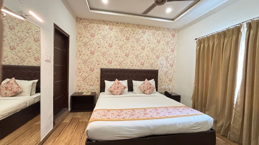 Elegant hotel room with a spacious bed, ceiling fan, modern amenities, window drapes, and elegant interior design at Sumitel Premier Inn.
