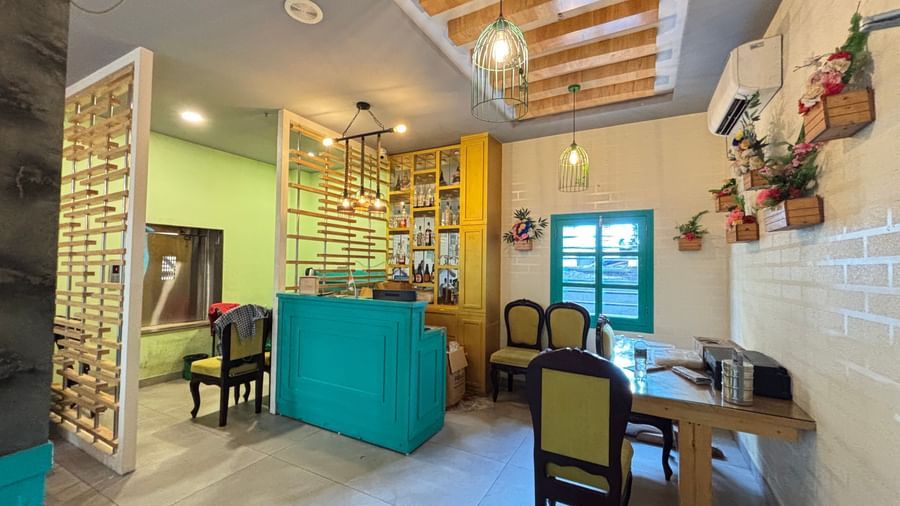 Bright, modern interior with wooden ceiling beams, green reception counter, chairs, and tables at Sumitel Premier Inn.