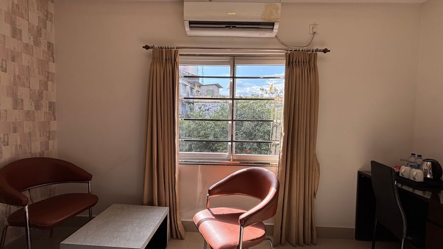 Seating area in a hotel room with two chairs, a table, and a window at Sumitel Premier Inn.