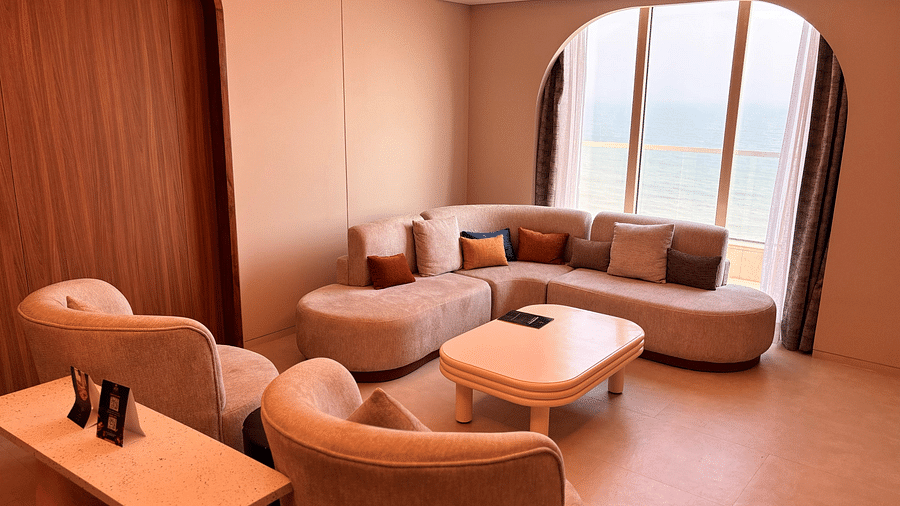 A living area at Swosti Premium Beach Resorts, Puri, with a couch, chairs, and a small table.