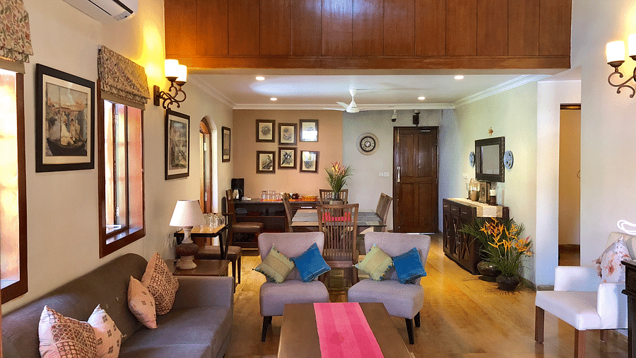 Living Area featuring a four seater sofa along with three couches behind which there is a six-seater dining table 