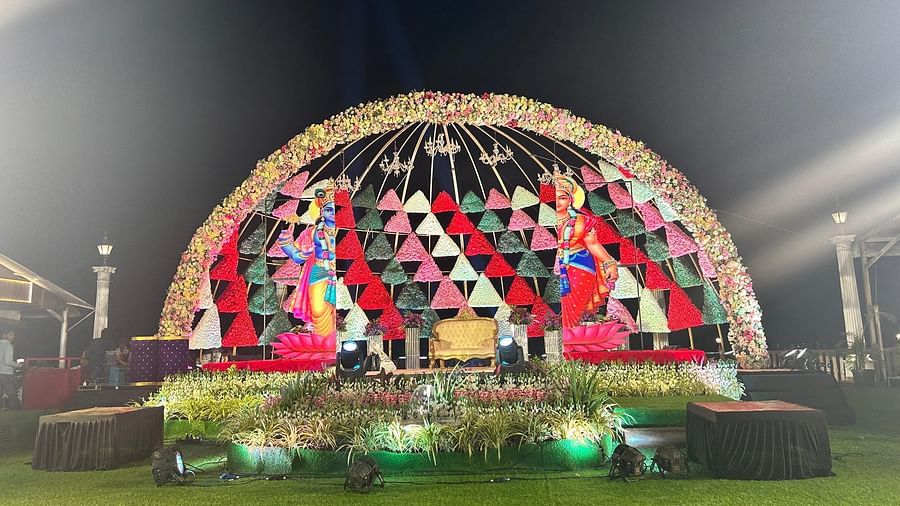 A stage set up designed in a dome style with flowers and images of Hindu gods and at the centre there is a sofa where bride and groom can sit - The Grand Legacy Resort & Spa