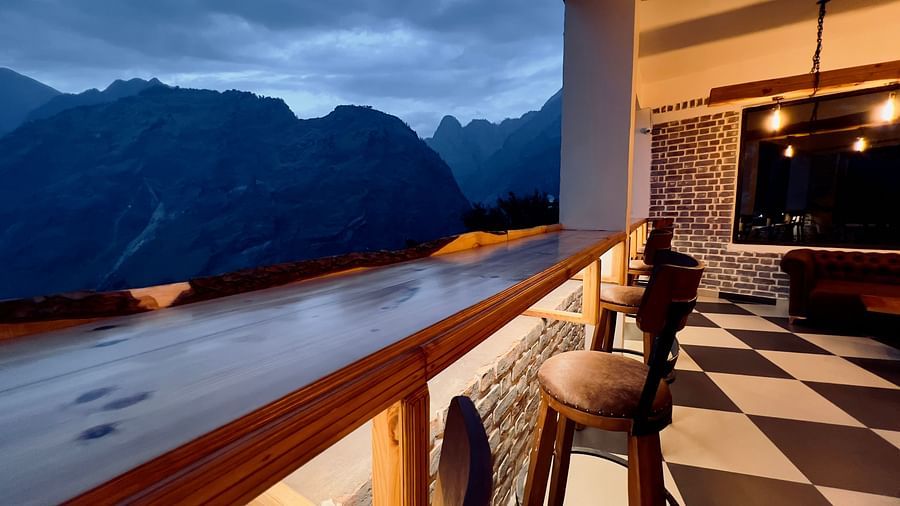 image of the bar with black and white titles and elevated chairs overlooking the beautiful mountain ranges in the background - The Tattva Boutique Resort