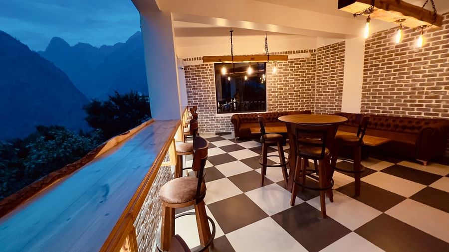 image of the alpenrose restaurant with black and white tiles overlooking at the amzing mountain views in the late evening - the tattva boutique resort 