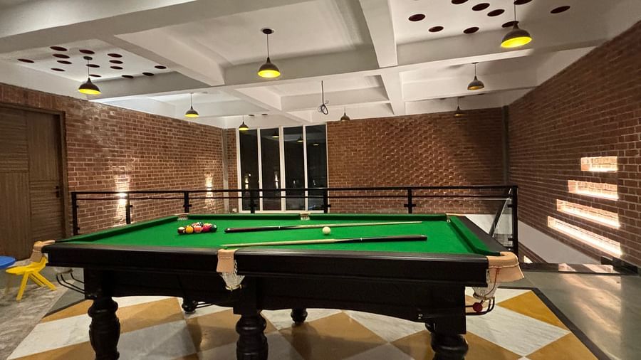 Indoor billiards room with green pool table and modern lighting at Tisya Farms, Gurgaon.