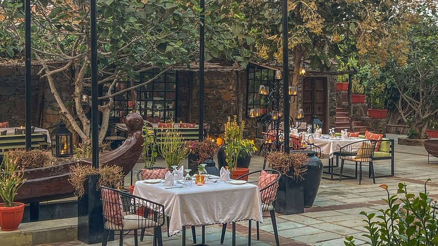 An image of an outdoor seating at the hotel with trees around - Utsav Camp Sariska