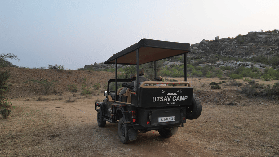 An image of a jeep parked amidst the rocky mountains - Utsav Camp Sariska
