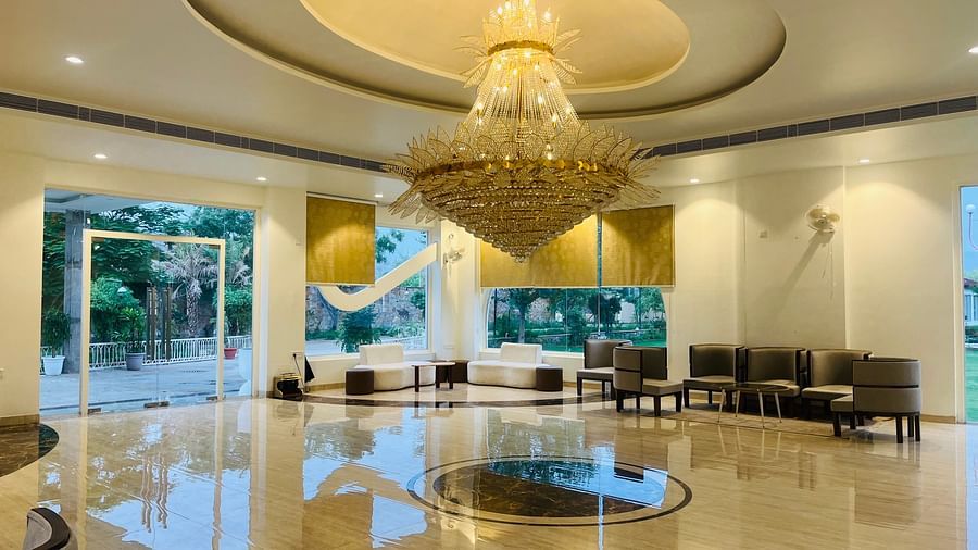 A reception area with a seating area and a large chandelier hanging from the ceiling at Valley by Grassfield.