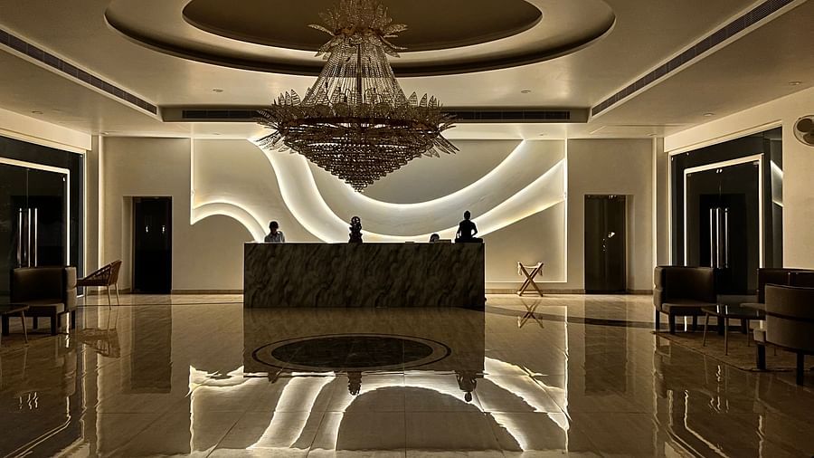 A dimly lit reception area with a front desk at the centre at Valley by Grassfield.