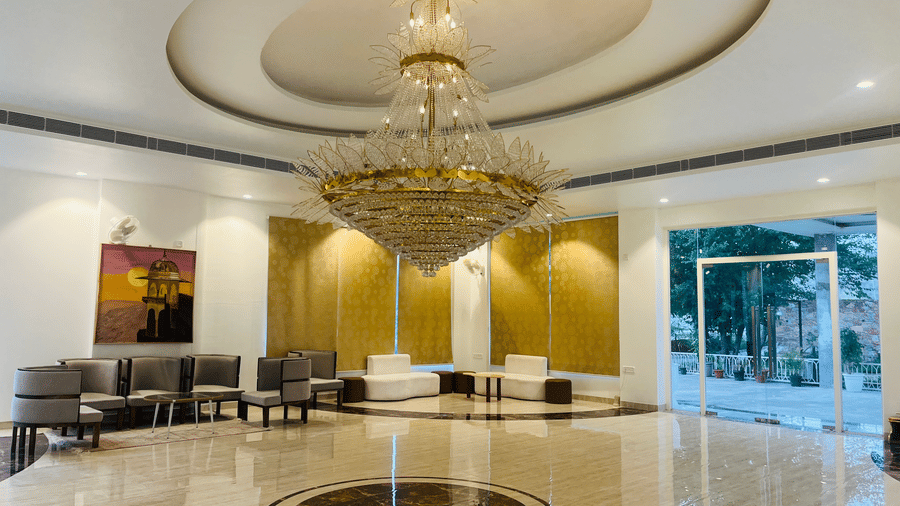 Close view of the lobby chandelier with seating behind at Valley by Grassfield, a resort in Jaipur.