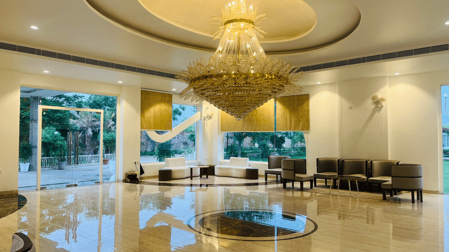 Reception seating beneath a large chandelier at Valley by Grassfield, a resort in Jaipur.