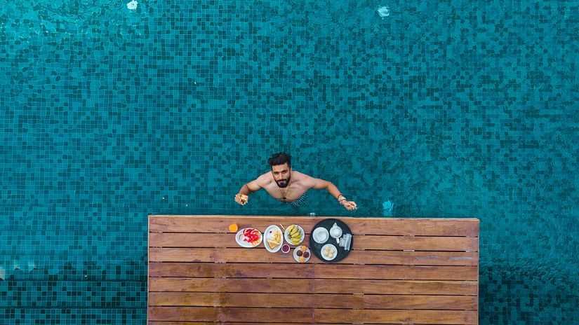 aerial shot of a man enjoying his food and drinks in the swimming pool - Symphony Samudra Beachside Jungle Resort And Spa, Port Blair