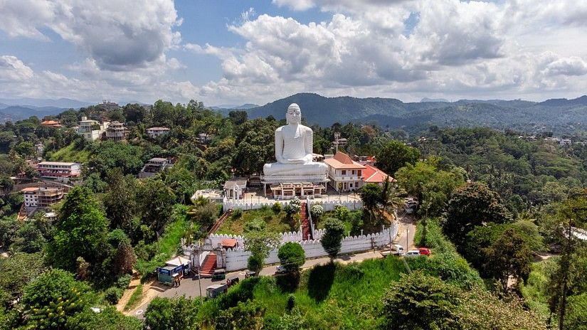 a white statue of Buddha on top of a building