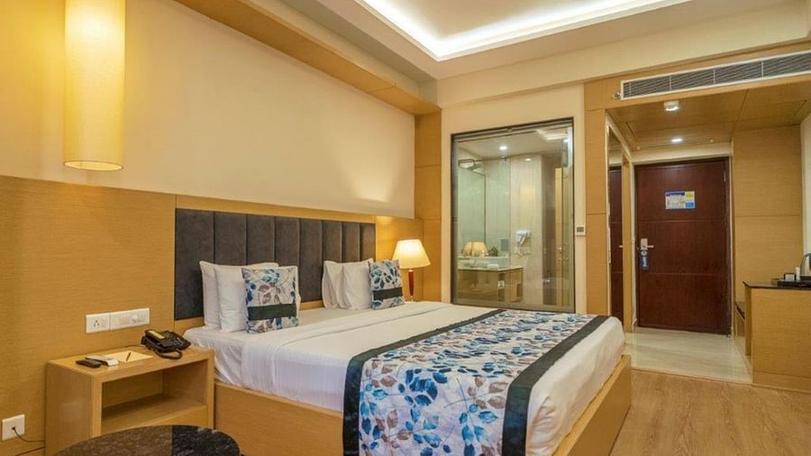 Premium Double pool room with a double bed, lamps, and wooden furnishings at Golden Tulip, Udaipur.