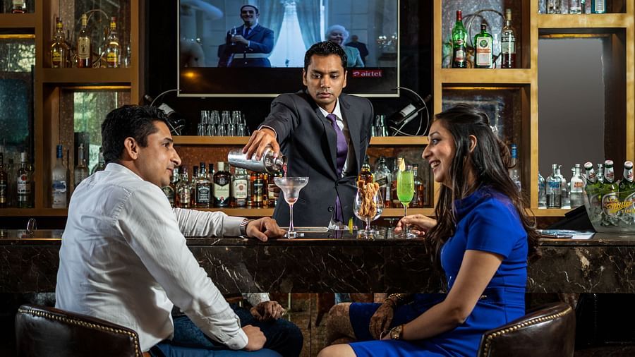 Two people enjoying the drinks in the bar at Golden Suites, Gurgaon