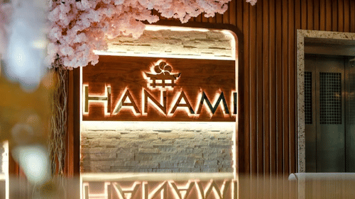Entrance of Hanami Pan-Asian Restaurant at Uday Suites, adorned with floral decor and warm lighting.