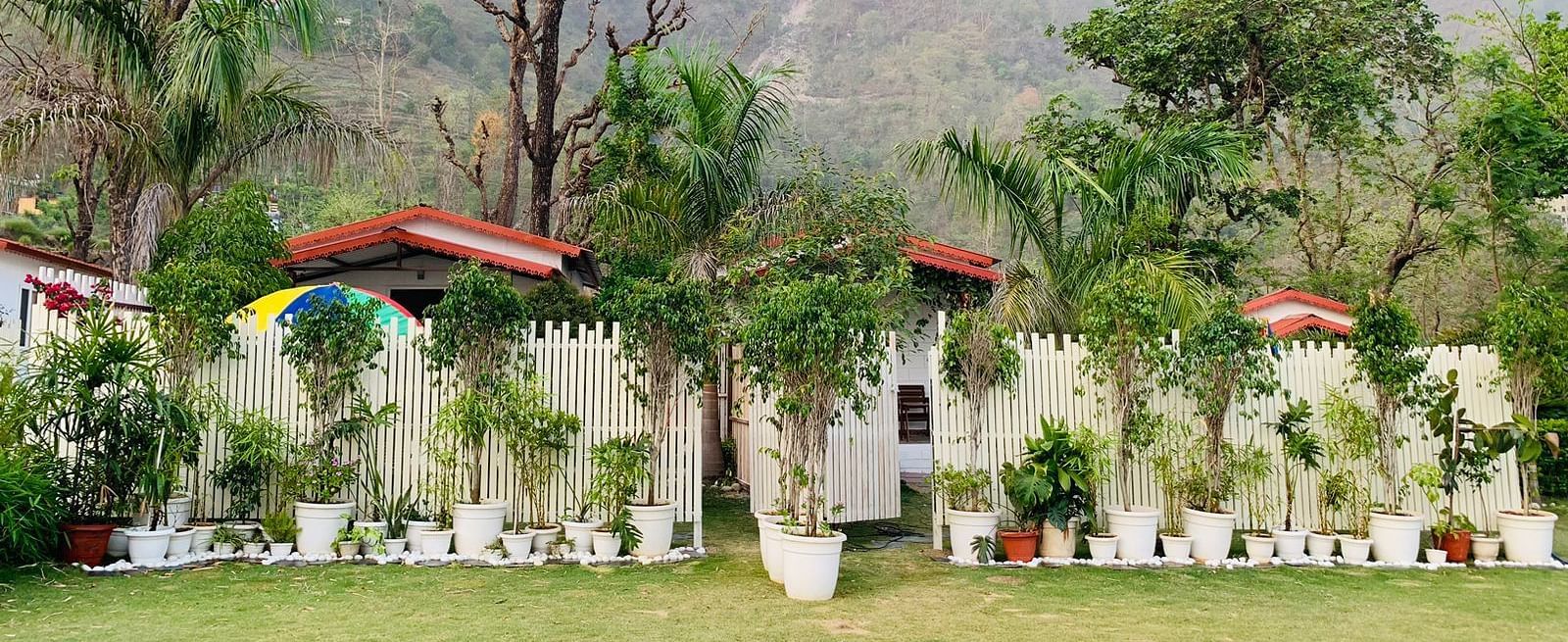 the garden area with potted plants and small trees at Neer Ganga Resorts