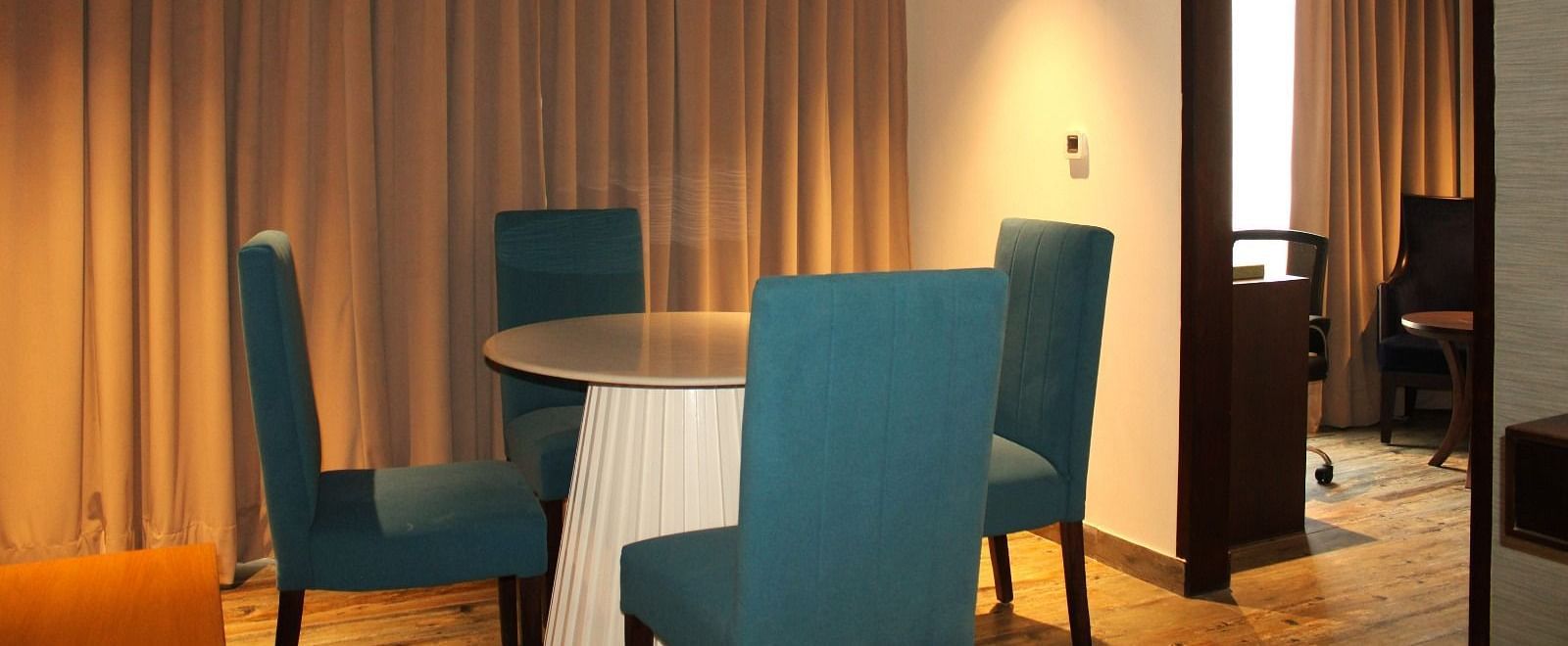 Close-up view of the dining space in the suite featuring a table and chairs at BluSalzz Residence, Amritsar.